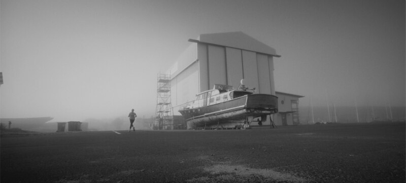 Corredor solitario en un muelle brumoso
