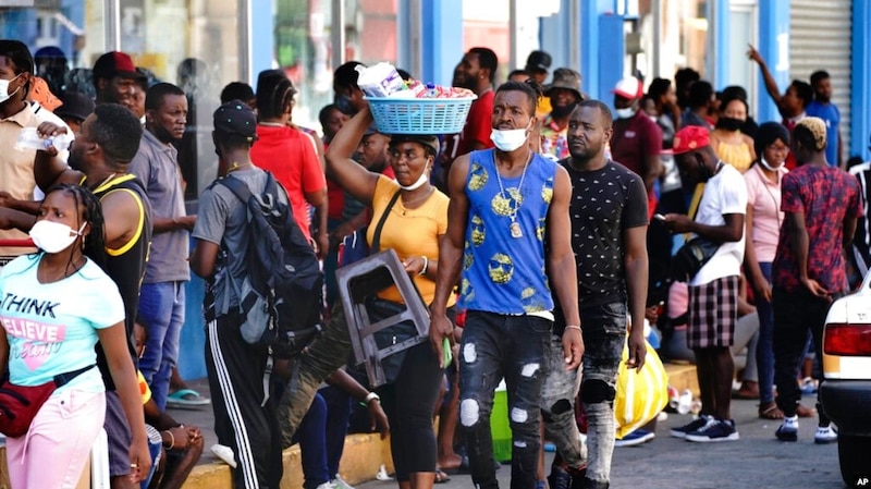 Multitud de personas esperando en una cola en una calle de Puerto Príncipe, Haití