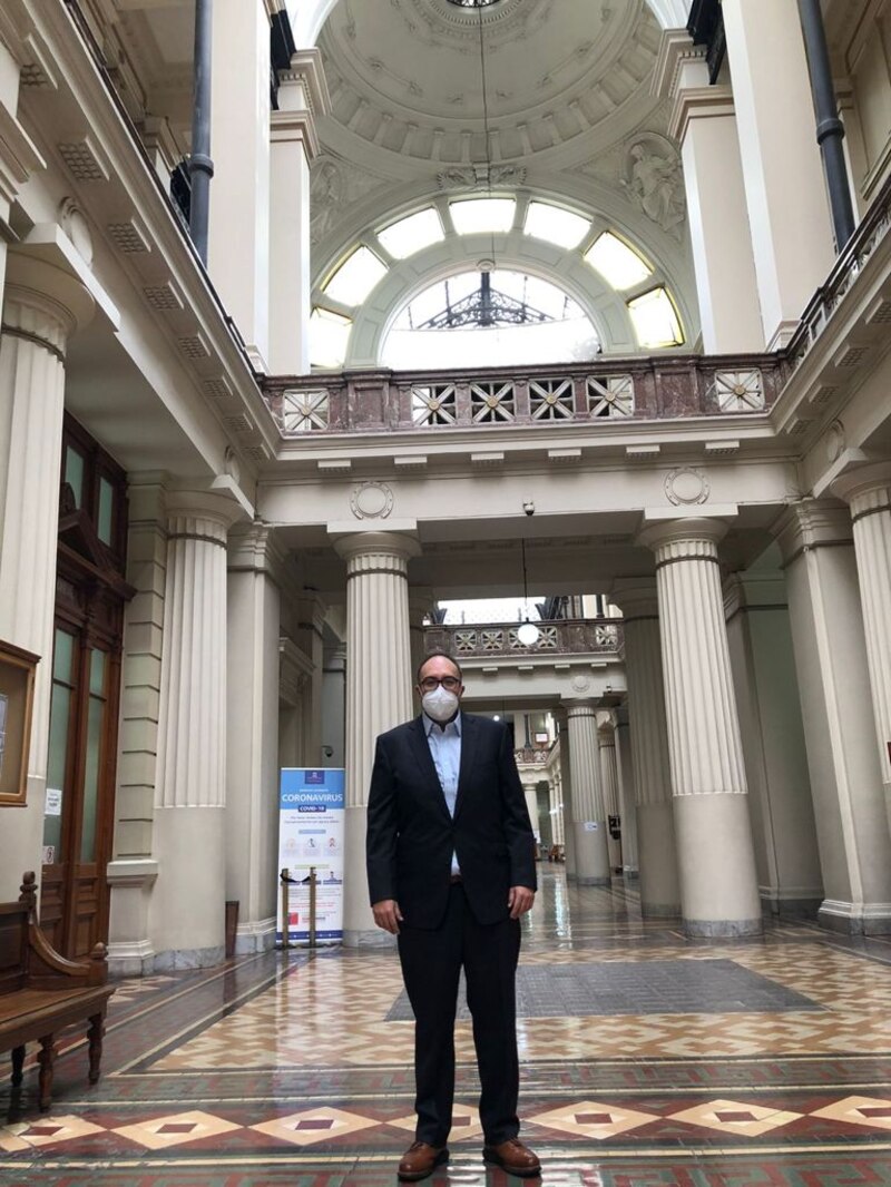 Un hombre con traje y mascarilla en un edificio gubernamental