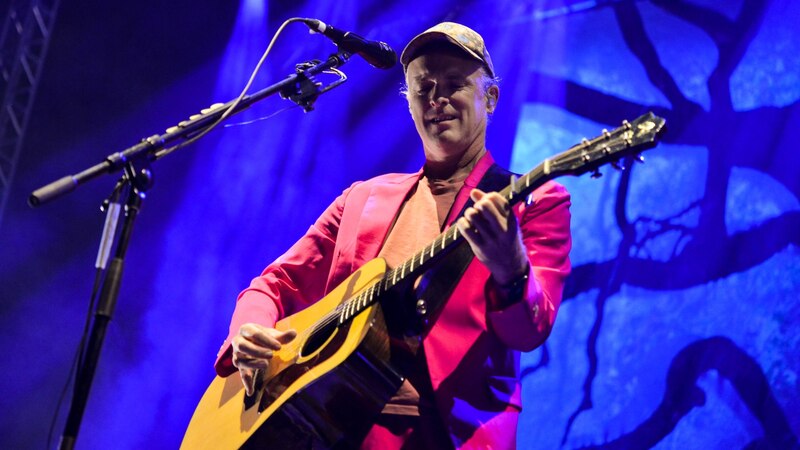 El músico Beck canta y toca la guitarra en un concierto.