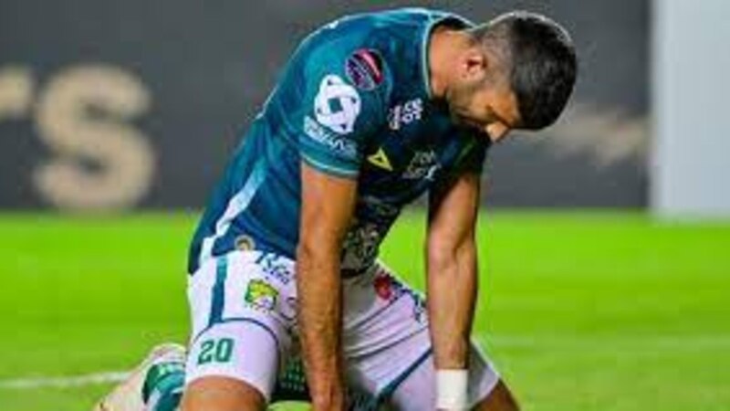 Jugador de fútbol arrodillado en el suelo