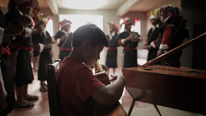 Niño tocando un instrumento musical andino