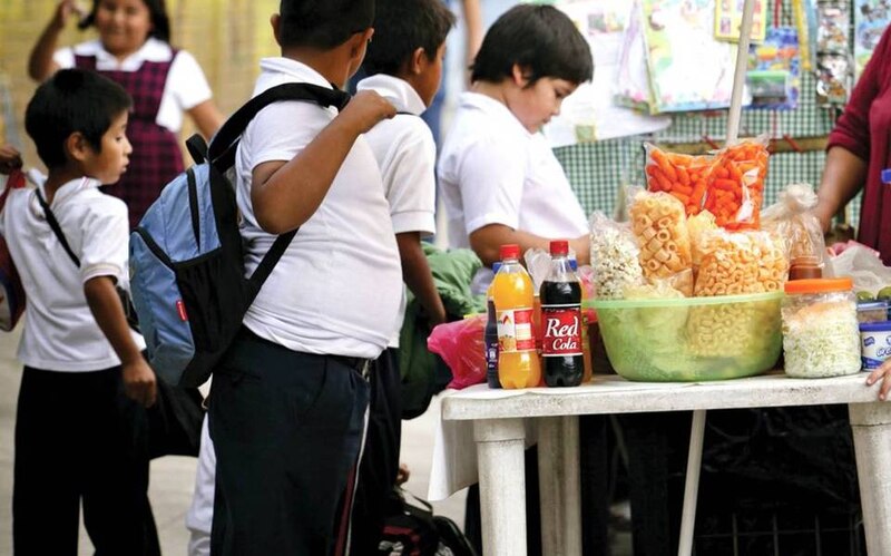 Niños mexicanos comprando comida chatarra en la calle