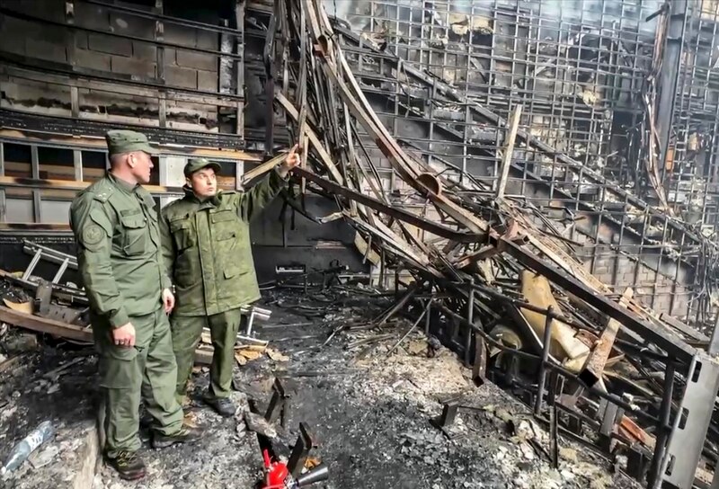 Bomberos inspeccionan los daños causados por un incendio en un edificio