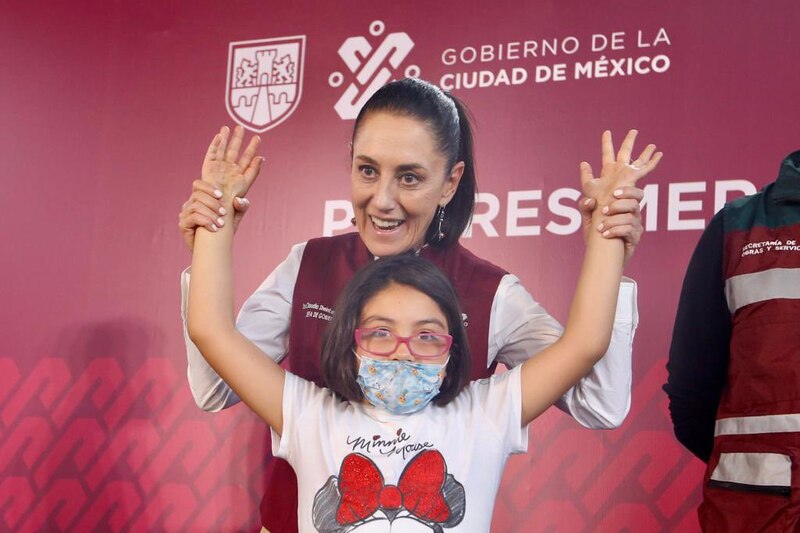 Title: La Jefa de Gobierno, Claudia Sheinbaum, saluda a una niña durante un evento público.