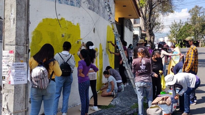 Jóvenes pintando un mural en una pared