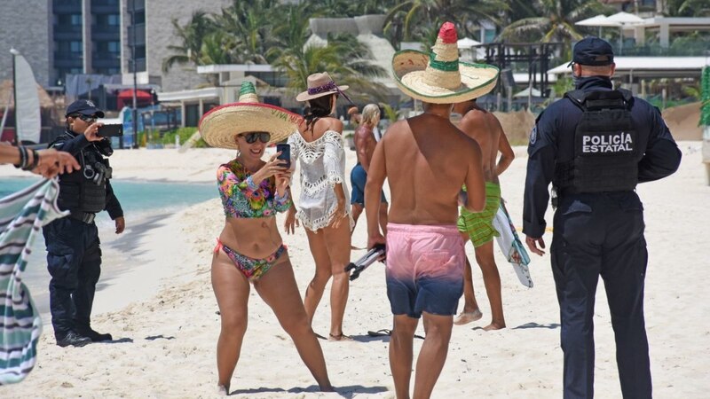 Policías mexicanos en Cancún vigilan a turistas en la playa