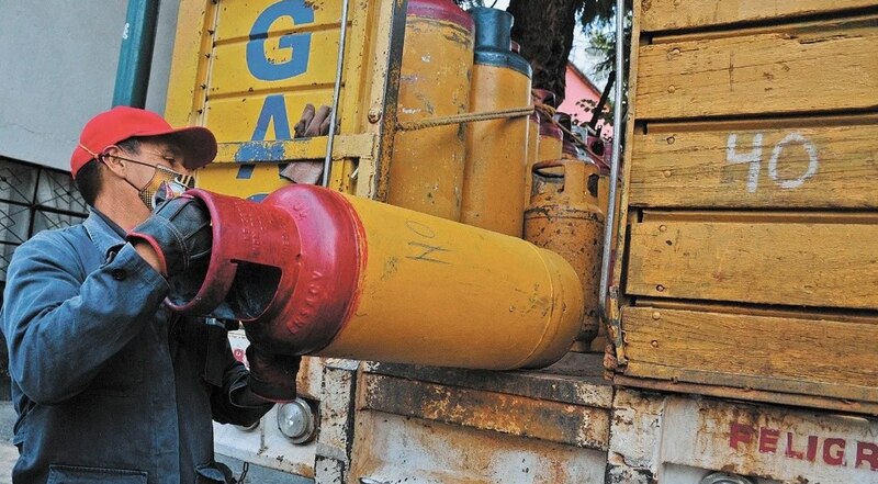 Un hombre carga un tanque de gas LP