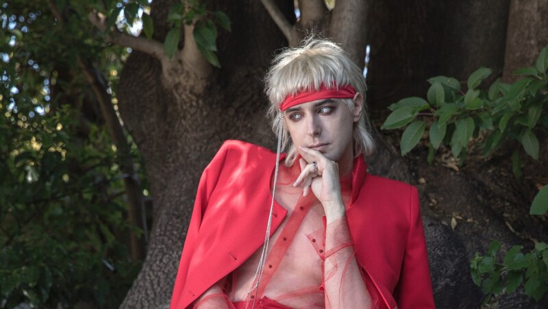 Un modelo con un traje rojo y una bandana roja en la cabeza