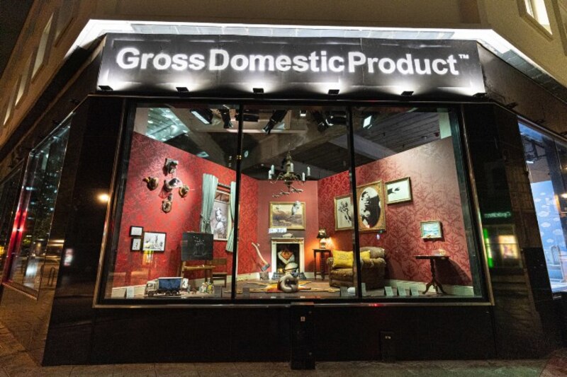 La ventana de una tienda muestra un interior con muebles y objetos rotos
