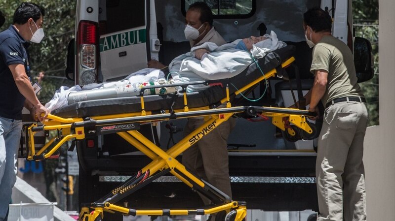 Paciente con COVID-19 es trasladado a una ambulancia