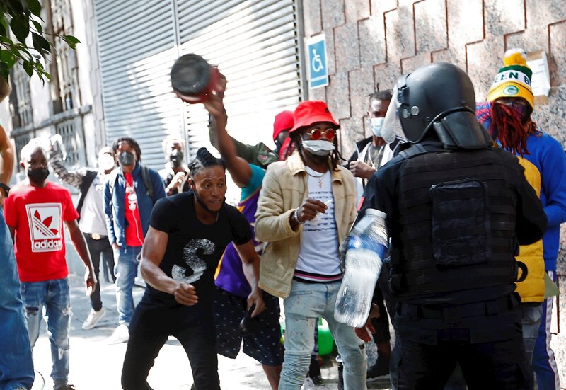 Enfrentamientos entre manifestantes y policías en las calles de una ciudad.