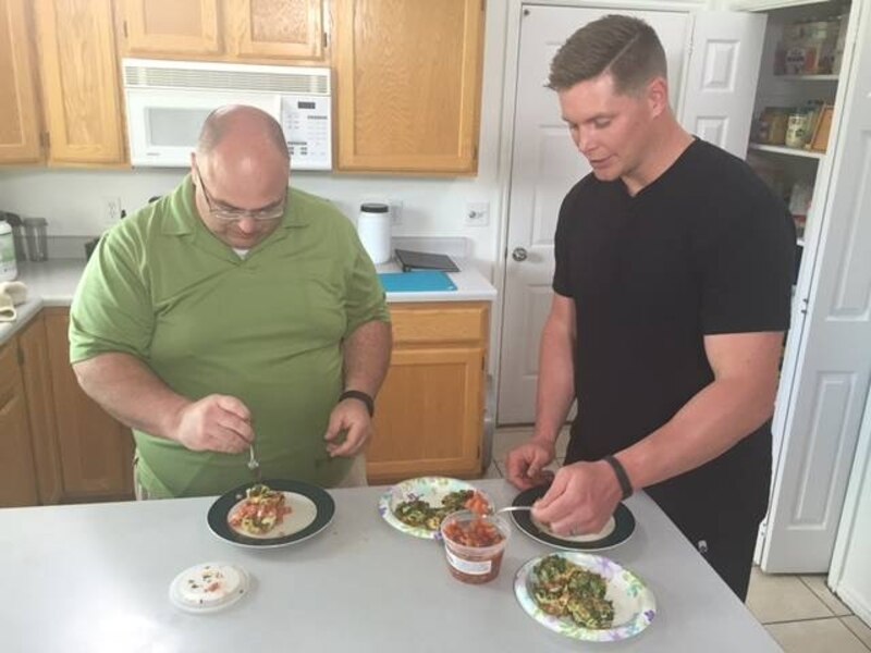Dos hombres preparando comida en la cocina