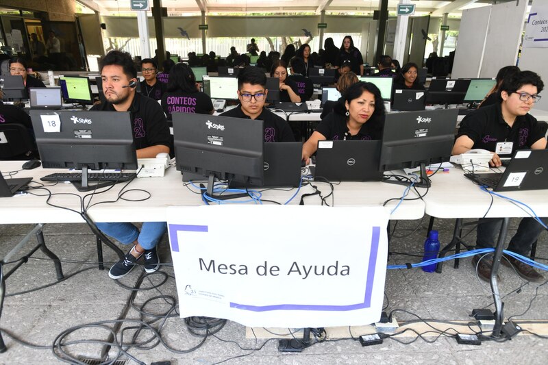 Jóvenes usando ordenadores en una mesa de ayuda