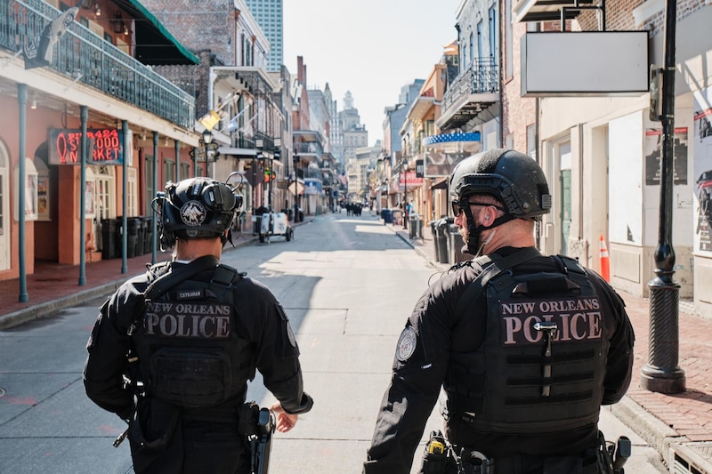 Miembros del Departamento de Policía de Nueva Orleans caminan por Bourbon Street antes de su reapertura al público en Nueva Orleans