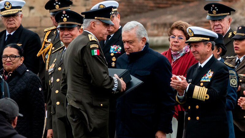El presidente Andrés Manuel López Obrador saluda a militares durante un evento público.