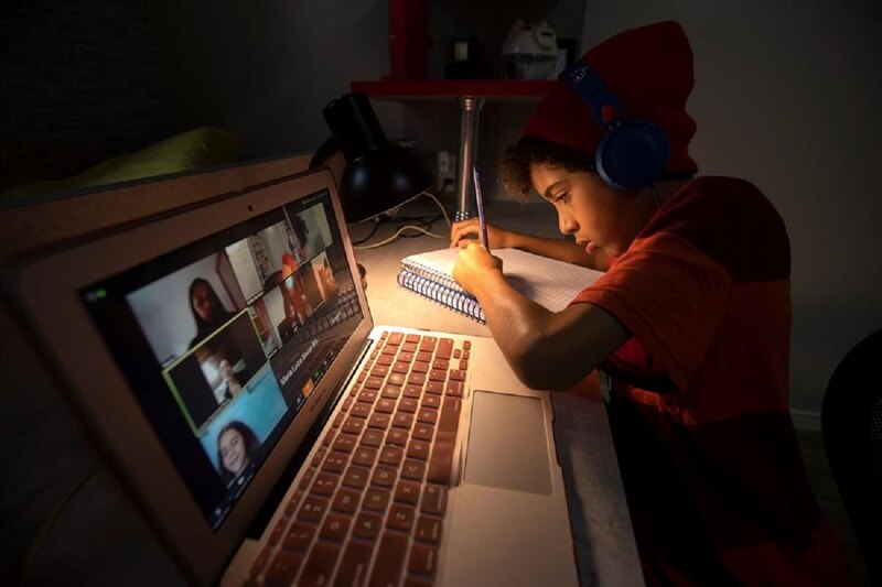Niño en casa usando la computadora para hacer la tarea