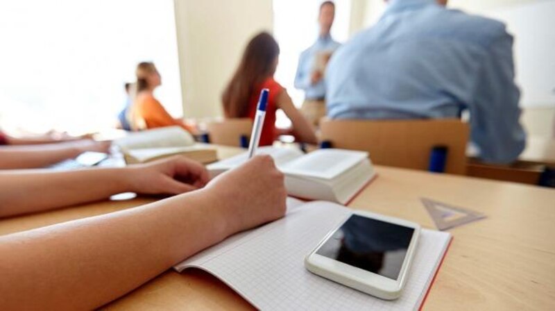 Estudiantes tomando apuntes en clase