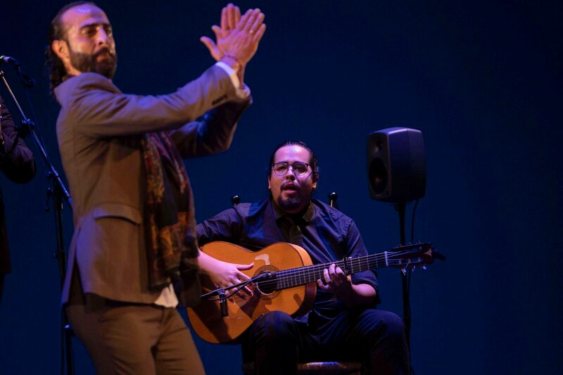 Un hombre canta y toca la guitarra mientras otro baila flamenco