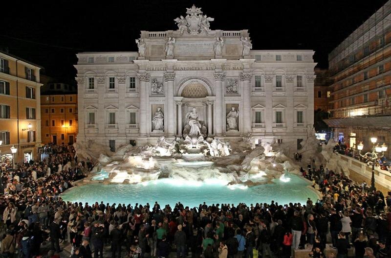 Multitud de turistas en la Fontana di Trevi de noche