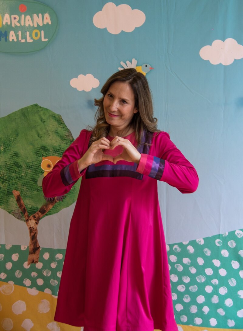 La artista Mariana Mallol formando un corazón con sus manos