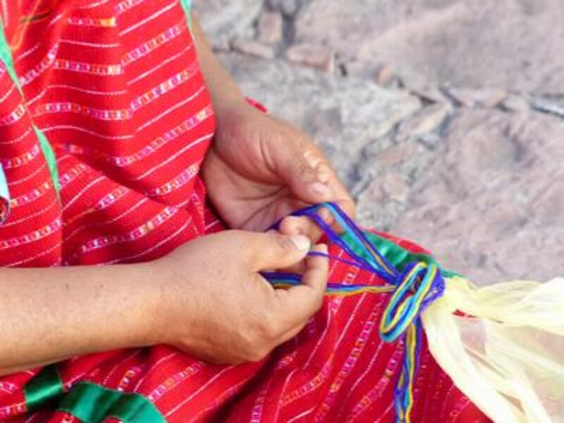 Mujer indígena tejiendo un huipil
