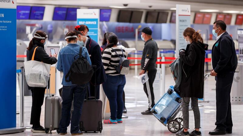 Pasajeros esperan en fila para abordar un avión en el aeropuerto
