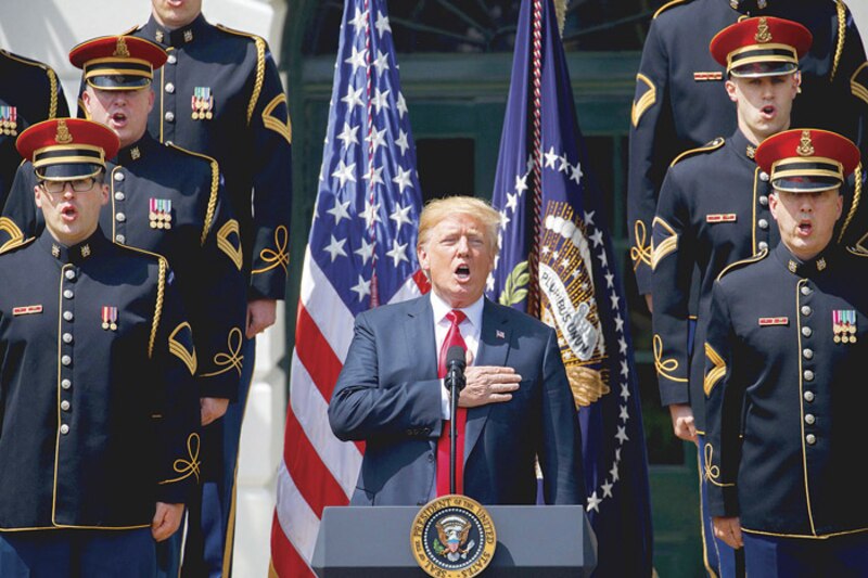 El presidente Trump canta el himno nacional en una ceremonia en la Casa Blanca.