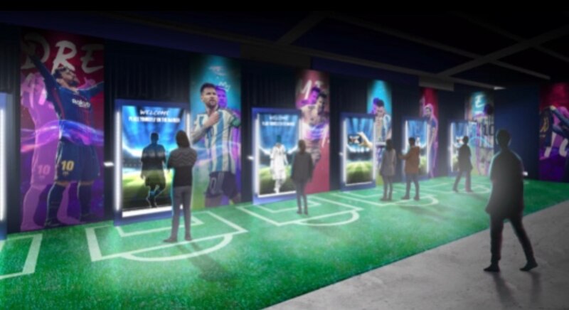 La imagen muestra el interior de un museo dedicado al fútbol, con varias pantallas que muestran imágenes de jugadores y momentos históricos del deporte.