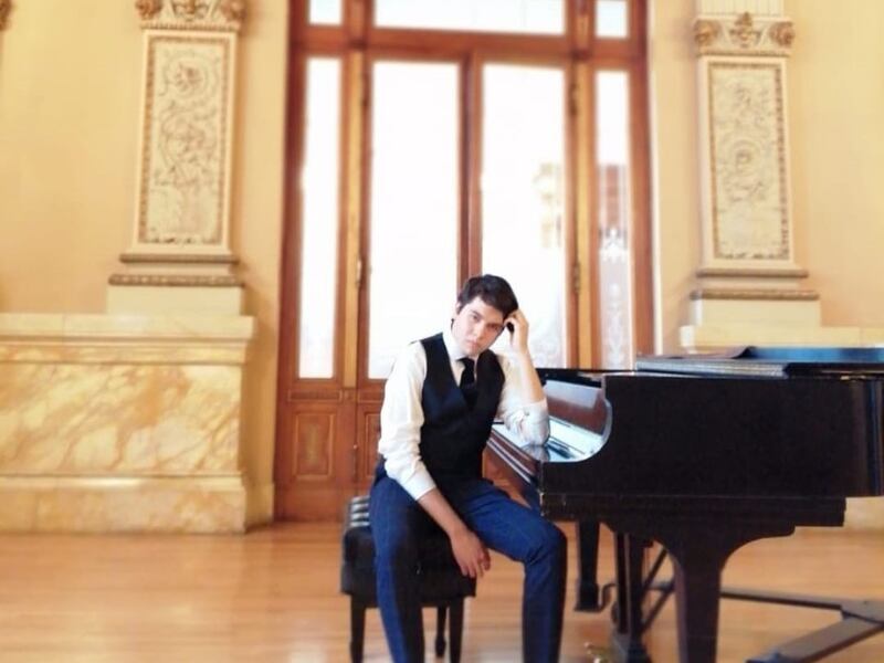 Joven pianista sentado en el piano
