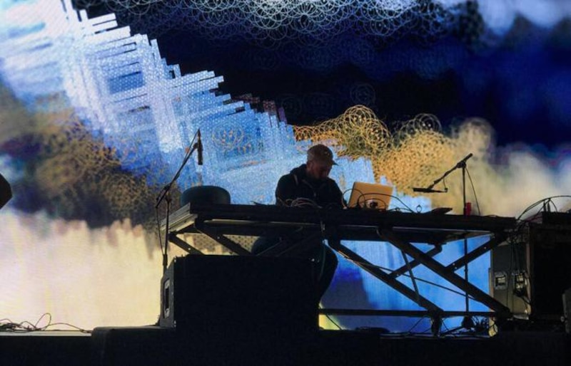 Un DJ usando una computadora portátil para mezclar música en un concierto