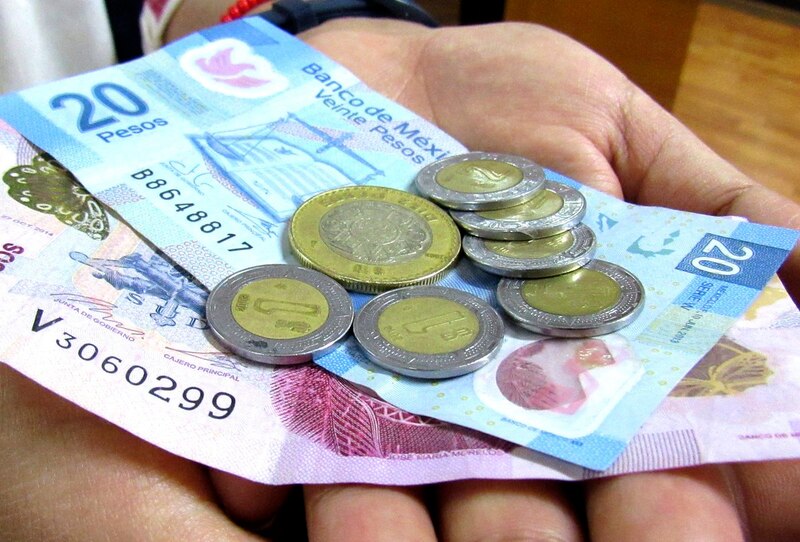 Monedas y billetes en la mano