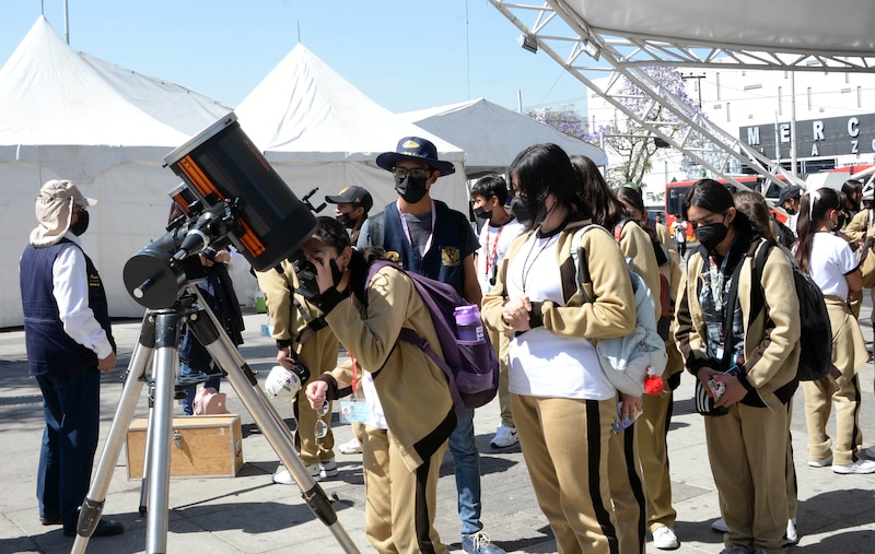 Jóvenes observando el cielo con un telescopio