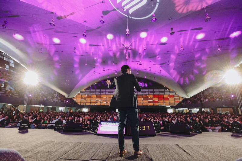 Un orador da una charla en un auditorio lleno de gente.