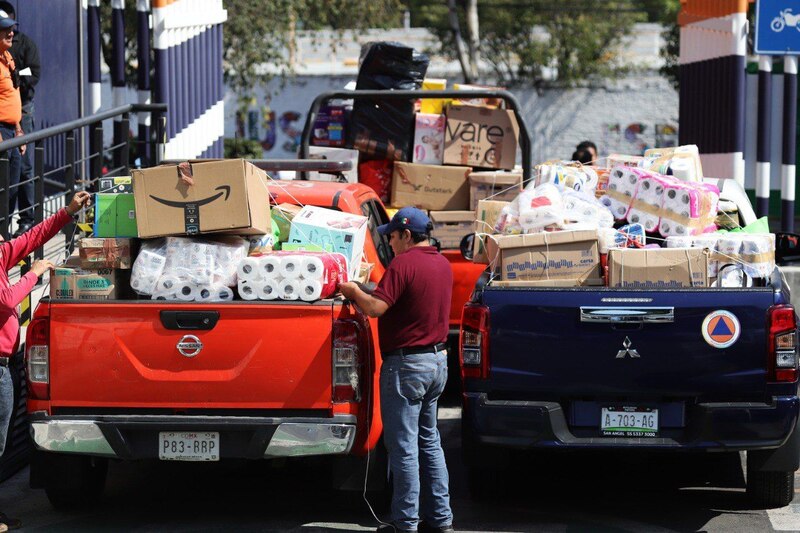Dos hombres cargando una camioneta con muchos productos