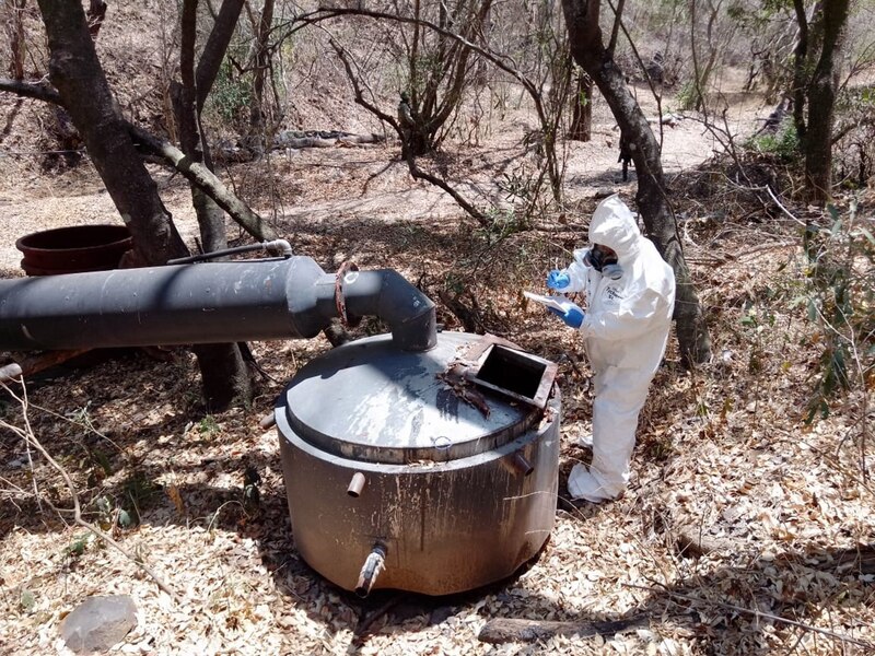 Un trabajador con traje de protección inspecciona una tubería en un bosque