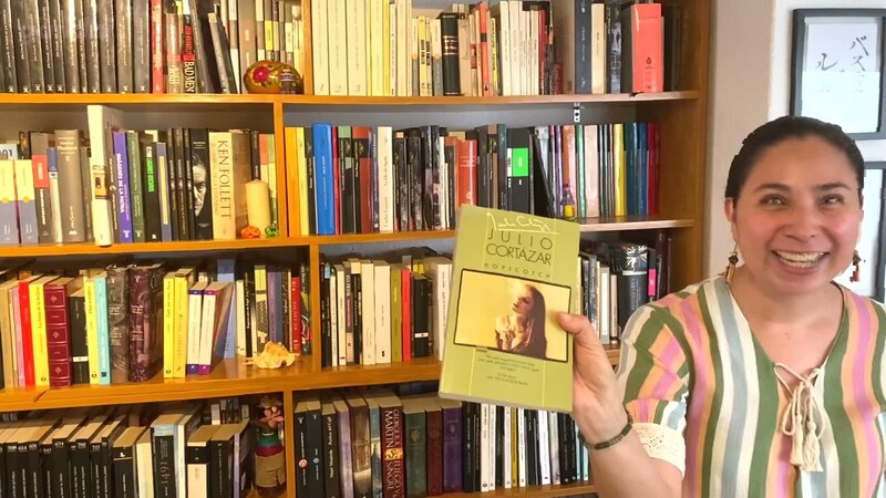 Mujer sosteniendo un libro en una biblioteca