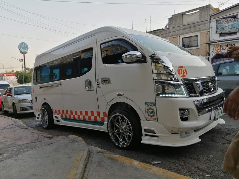 Furgoneta blanca con gráficos personalizados y rines cromados