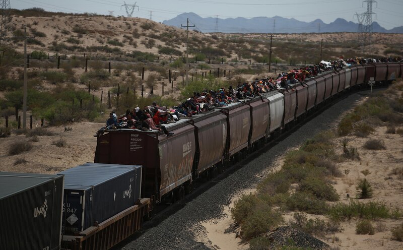 Migrantes centroamericanos viajan en tren en México