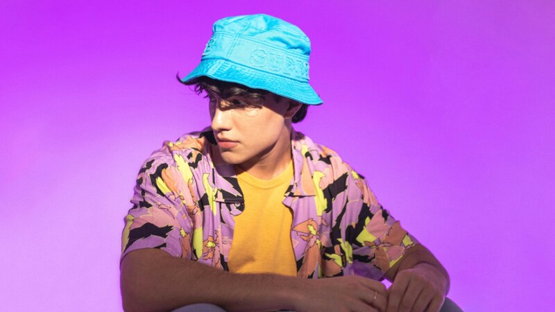 Joven con sombrero azul y camisa hawaiana