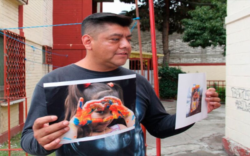 Un padre sostiene una foto de su hija desaparecida