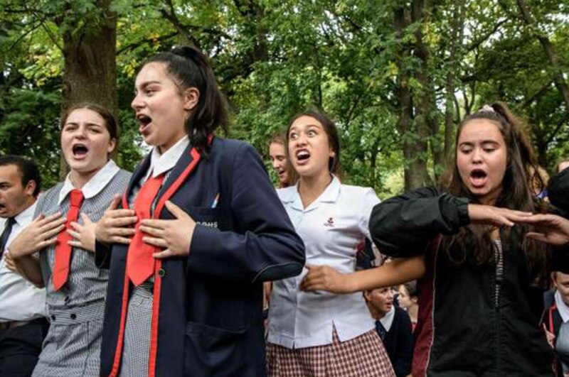 Estudiantes cantando el himno nacional en una ceremonia escolar