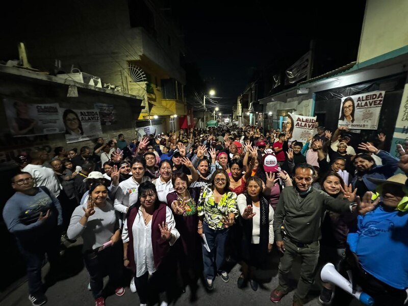 Multitud de personas en una calle estrecha enarbolando banderas y carteles con el nombre de Aleida Alavez
