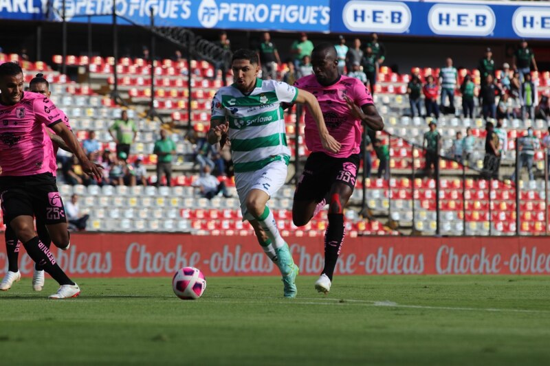 Jugadores de fútbol corriendo tras el balón
