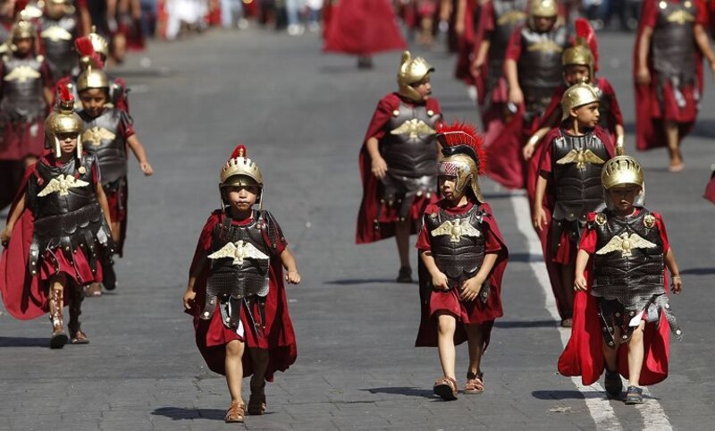 Niños vestidos de soldados romanos en una procesión de Semana Santa