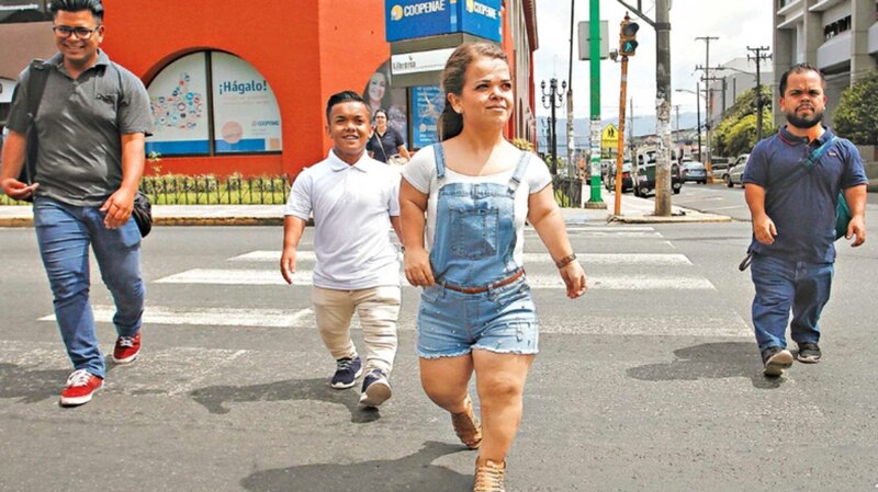 Personas con acondroplasia caminan por una calle de la ciudad.