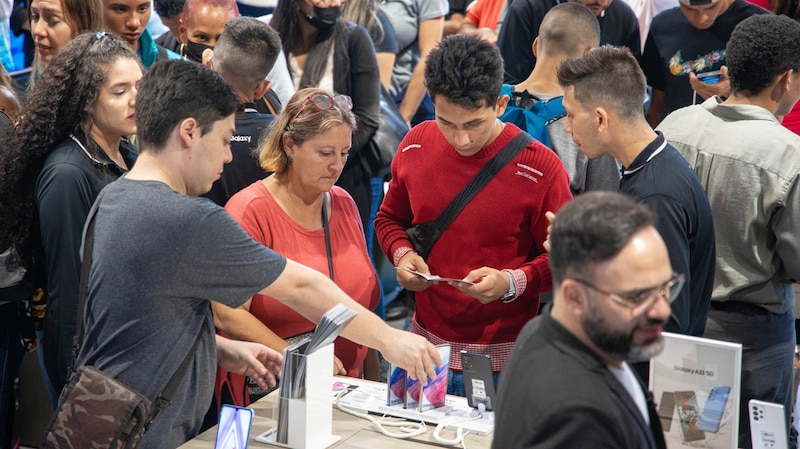 Personas en un mall comprando celulares