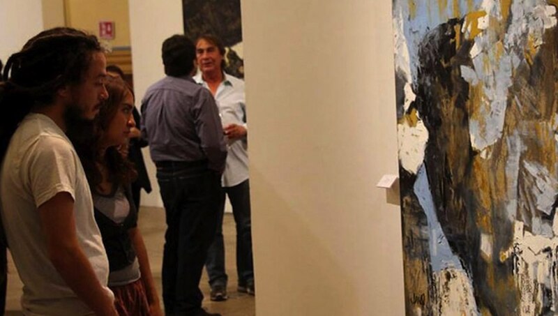 Pareja admirando una pintura abstracta en una galería de arte.