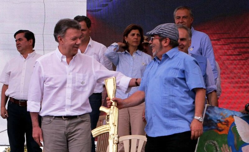 Hugo Chávez entrega un fusil de oro a Fidel Castro.