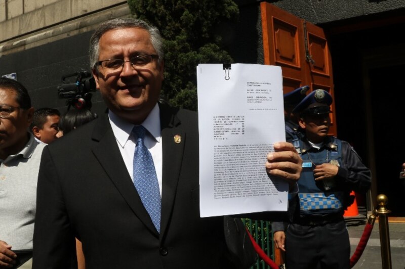 El presidente electo de México, Andrés Manuel López Obrador, muestra la Constitución Política de los Estados Unidos Mexicanos.
